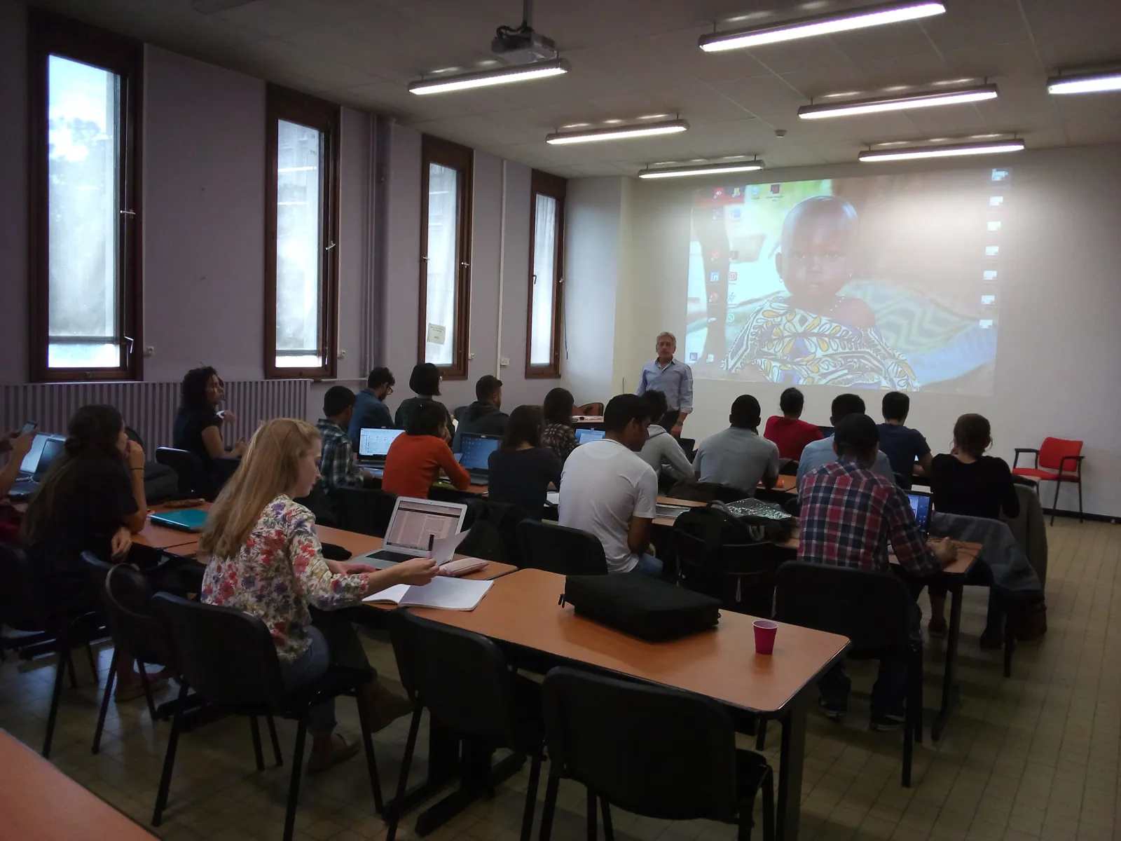 Étudiants suivant le cours de communication santé, avec projection d'une photo d'enfant